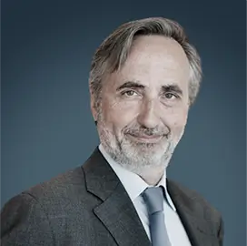 Armand de Villoutreys – President, Firmenich | RLC Global Forum Portrait of Armand de Villoutreys, President of Firmenich, wearing a gray suit and tie, smiling against a blue background.