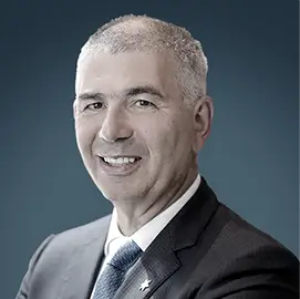 Patrick Chalhoub | RLC Global Forum Patrick Chalhoub, Executive Chairman of Chalhoub Group, wearing a dark suit and tie, smiling.