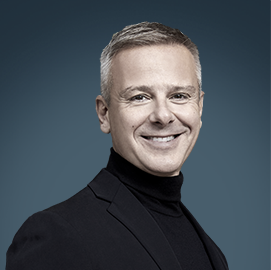 Simone Dominici – CEO, KIKO Milano | RLC Global Forum Portrait of Simone Dominici, CEO of KIKO Milano, wearing a black turtleneck and smiling against a blue background.