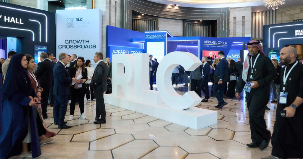 Attendees networking at the 2026 RLC Global Forum in Riyadh, gathered around large white “RLC” letters in an exhibition hall.