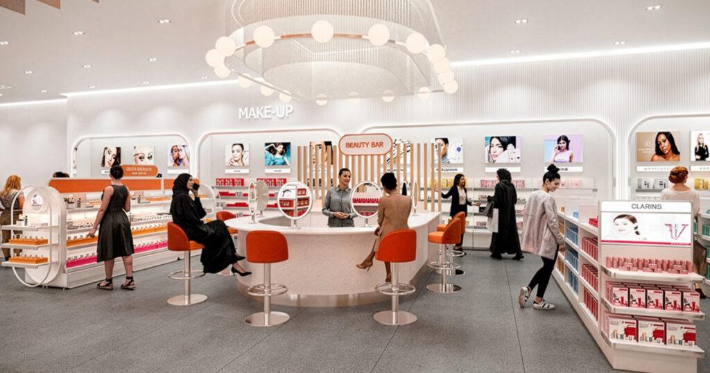 Interior of an Ulta Beauty store, featuring makeup displays, a central Beauty Bar with orange stools, and customers browsing products under bright lighting.