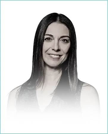 Portrait of Lana Todorovich, Chief Global Brands Officer at Saks Global, smiling against a teal background.
