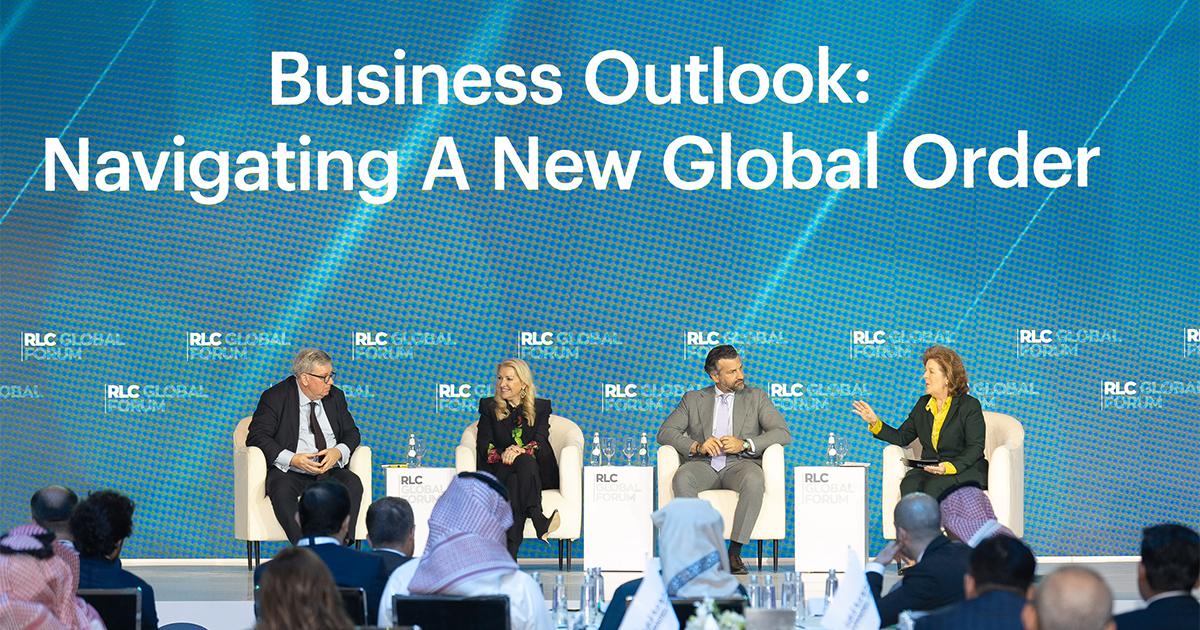 Four panel discussion speakers seated on stage under a blue backdrop titled Business Outlook Navigating A New Global Order at RLC Global Forum.