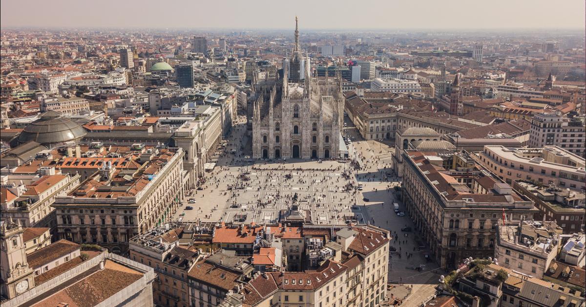 Aerial view of Milan’s Piazza del Duomo, with the Duomo di Milano at the center and the surrounding cityscape stretching into the distance.